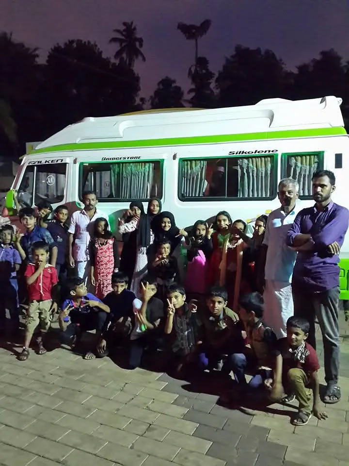 Large family group with children posing in front of an Anshaj tempo traveller