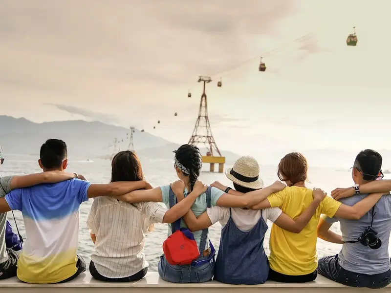 Group of students on a trip with their arms around each other